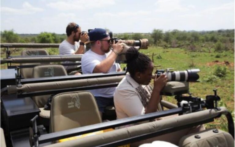 Group of wildlife photographers on safari in South Africa, using professional cameras to capture stunning images of African wildlife