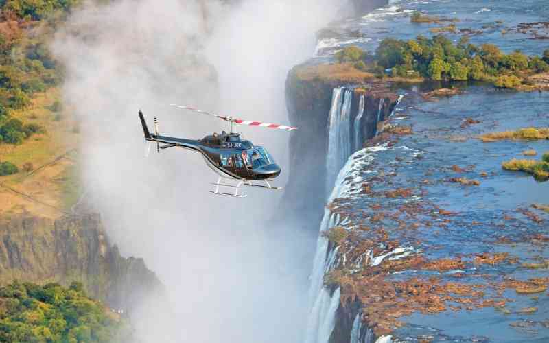 Helicopter flying over Victoria Falls, one of Africa’s most extraordinary aerial safari experiences.