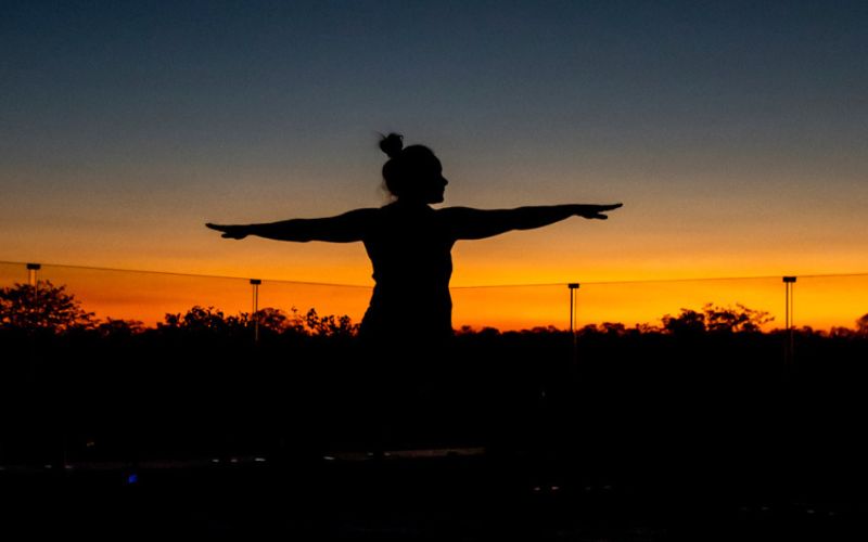Guest practising sunset yoga on safari, showcasing mindful activities included in wellness safari itineraries.