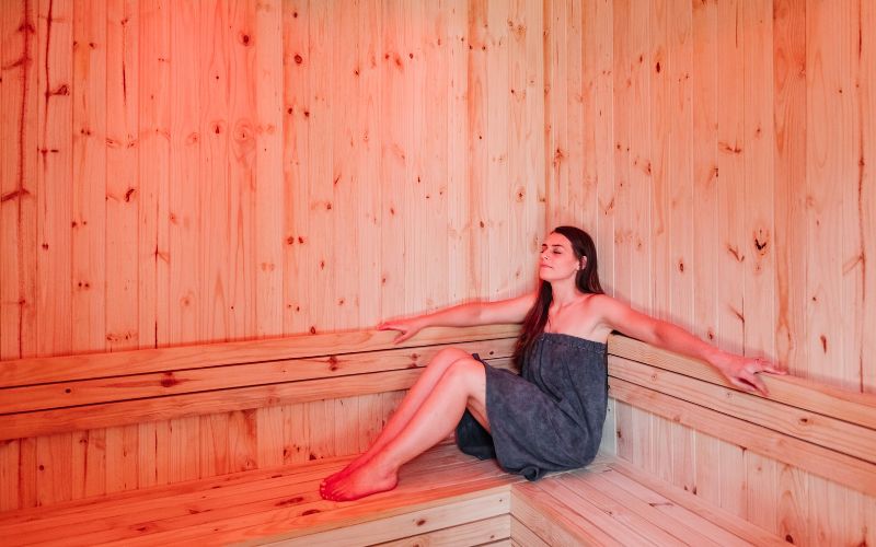 Guest relaxing in a wooden sauna, highlighting the wellness treatments offered on modern wellness safar.