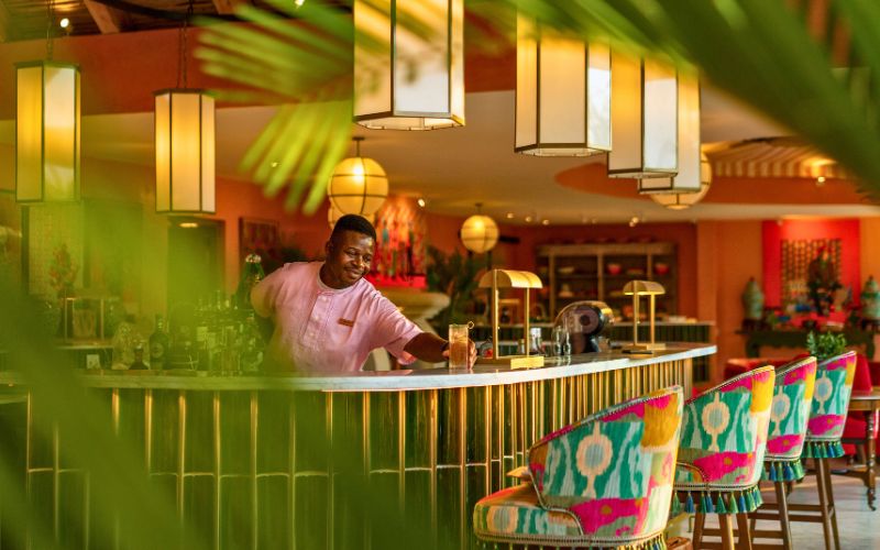 Barman preparing cocktails at the colourful bar inside Royal Malewane Masiya’s Camp, a key feature highlighted